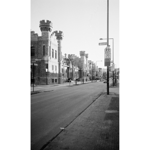homepage: feature image of black & white prints; an empty street with a car and gigantic houses