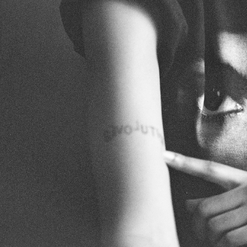 Love; a revolution, a girl showing a tattoo entitled revolution